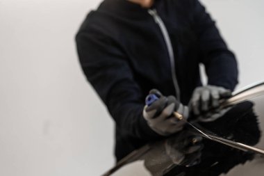 Ön cam kaldırma işlemi özel kesme kablosu ve kazıma aracı kullanılarak yapılıyor. Otomobil teknisyeni ön camı ince tel ve kazıma bıçağı kullanarak ayırıyor. Arabanın ön camını değiştirme işlemi