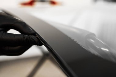 Dikensiz araba camı montajı için yapıştırıcı sürmeden önce ön camı inceliyorum. Ön cam kenarı mühürleme hazırlığı. Teknisyen arabanın ön camını kurulum için hazırlıyor.