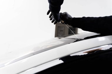 Ön cam kaldırma işlemi özel kesme kablosu ve kazıma aracı kullanılarak yapılıyor. Otomobil teknisyeni ön camı ince tel ve kazıma bıçağı kullanarak ayırıyor. Arabanın ön camını değiştirme işlemi