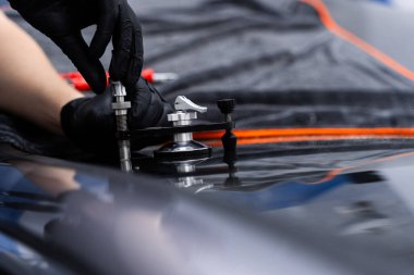 Yapısal berraklığı geri getirmek için enjektör uygulaması kullanarak ön camda reçine onarımı. Reçine enjeksiyonuyla ön cam çatlağı onarımı. Teknisyen ön cam enjektörü kullanarak göz çatalını tamir ediyor.