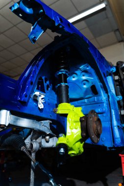 Drift Car Build için Chassis Altında Arka Süspansiyon Kurulumu. Teknisyen şasinin altındaki kol ve alt çerçeve bağlantılarını sıkılaştırıyor. Arka süspansiyon kolları şasinin altına yerleştiriliyor.