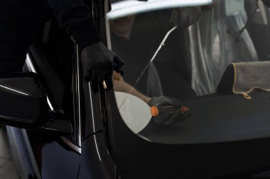 Ön cam kaldırma işlemi özel kesme kablosu ve kazıma aracı kullanılarak yapılıyor. Otomobil teknisyeni ön camı ince tel ve kazıma bıçağı kullanarak ayırıyor. Arabanın ön camını değiştirme işlemi