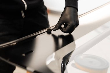 Araba çerçevesine siyah astar takmak güçlü bir yapışmayı garantiler. Ön cam kurulumundan önce araba çerçevesine astar takılıyor