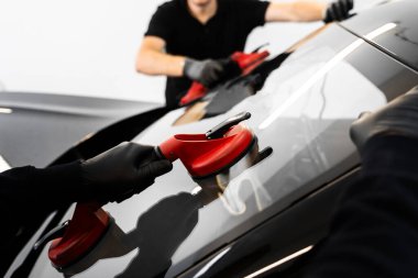 Aspirasyon asansörlerini kullanarak ön cam kurulumu. İki teknisyen vantilatör kullanarak ön cam kuruyor. Ön cam yerleştirilmesi, güvenlik ve bütünlük sağlar. Yeni Ön Kalkan kurulum süreci