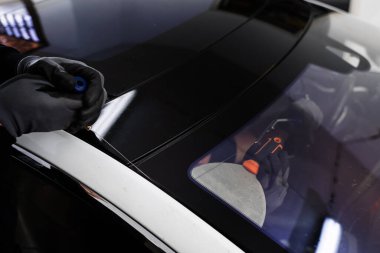 Ön cam kaldırma işlemi özel kesme kablosu ve kazıma aracı kullanılarak yapılıyor. Otomobil teknisyeni ön camı ince tel ve kazıma bıçağı kullanarak ayırıyor. Arabanın ön camını değiştirme işlemi