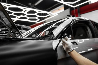 Tam panelli araba plastiği paketleme. Büyük ölçekli vinil ambalaj kurulumu aracın dış yüzeyini mat siyah filmle dönüştürür. Araba sarma uygulaması araç görünümünü değiştirir