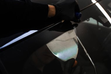 Ön cam kaldırma işlemi özel kesme kablosu ve kazıma aracı kullanılarak yapılıyor. Otomobil teknisyeni ön camı ince tel ve kazıma bıçağı kullanarak ayırıyor. Arabanın ön camını değiştirme işlemi