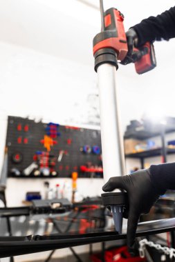 Bir arabanın ön camına kabartma tabancası kullanarak yapıştırıcı sürüyorum. Urethane kazıma silahı, arabanın ön camının değiştirilmesinde su geçirmez bir mühür oluşturarak esnek bir yapıştırıcı uyguluyor.