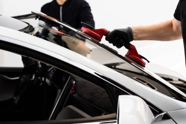 Aspirasyon asansörlerini kullanarak ön cam kurulumu. İki teknisyen vantilatör kullanarak ön cam kuruyor. Ön cam yerleştirilmesi, güvenlik ve bütünlük sağlar. Yeni Ön Kalkan kurulum süreci