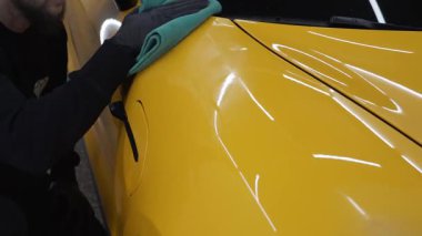 Araba cilası ve vale videosunun detaylarını özenle işledim. Adam araba servisinde prosedürü detaylandırmadan önce arabayı mikrofiber bezle cilalıyor..