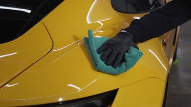 Mikrofiber el temizleme ve spor araba yıkama Garaj 4K video mikrofiber havlu kullanarak. Detaylı işlemden sonra mikrofiber bezle elle yıkama ve cilalama..