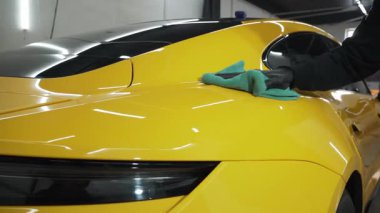 Mikrofiber el temizleme ve spor araba yıkama Garaj 4K video mikrofiber havlu kullanarak. Detaylı işlemden sonra mikrofiber bezle elle yıkama ve cilalama..