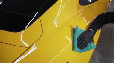 Mikrofiber el temizleme ve spor araba yıkama Garaj 4K video mikrofiber havlu kullanarak. Detaylı işlemden sonra mikrofiber bezle elle yıkama ve cilalama..