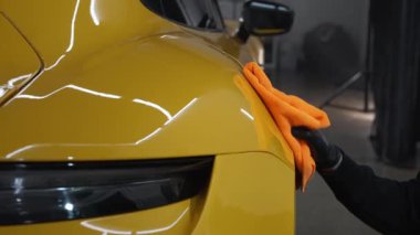 Mikrofiber el temizleme ve spor araba yıkama Garaj 4K video mikrofiber havlu kullanarak. Detaylı işlemden sonra mikrofiber bezle elle yıkama ve cilalama..