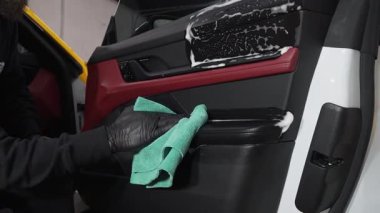 Mikrofiber el temizleme ve spor araba yıkama Garaj 4K video mikrofiber havlu kullanarak. Detaylı işlemden sonra iç arabayı mikrofiber bezle elle yıkama.