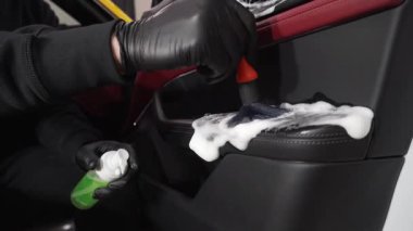 4K videosundaki araba kapısındaki toz ve kiri kaldırma işlemi. Araba temizleyicisi araba kapısını köpük fırça ve deterjanla temizliyor..