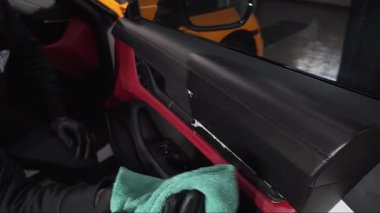 Mikrofiber el temizleme ve spor araba yıkama Garaj 4K video mikrofiber havlu kullanarak. Detaylı işlemden sonra iç arabayı mikrofiber bezle elle yıkama.