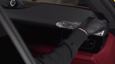 Arabanın kapı panelini deterjan 4K videosuyla temizleme işlemi. Sabunlu bir fırçayla arabanın kapısını temizleyen siyah bir eldiven verin. Ayrıntılı işlem.