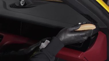 Prosedür 4k videosu detaylandırılıyor. Sabunlu bir fırçayla arabanın kapısını temizleyen siyah bir eldiven verin. Arabanın kapı panelini deterjanla temizleme işlemi.