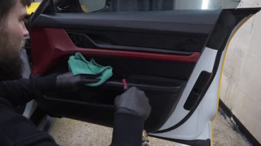 Araba kapısının iç tarafındaki buhar temizleme işlemi köpük üstüne deterjan yıkama ve fırça 4K video ile. Araba temizleme servisi. Temizlik işçisi, müşterilerin iç çamaşırlarını yıkıyor..