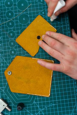 Deri ustaları dikiş atmadan önce kenar hazırlamak için yapıştırıcı kullanır. Deri kenarlara yapıştırıcı sürüyorum. Deri ürünler üretimi güçlü yapıştırıcıları güvenli bir şekilde yapıştırmakla başlar.