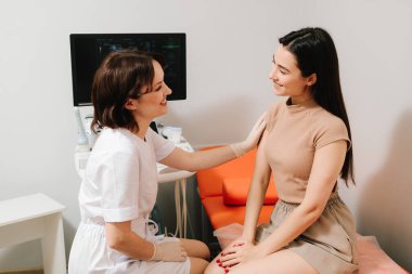 Ultrason muayenesinden önce jinekolog hastaya danışıyor. Jinekolog, jinekolojik muayeneden sonra kadını rahatlatıyor. Jinekologla muayene sonrası konsültasyon.