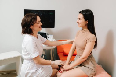 Ultrason muayenesinden önce jinekolog hastaya danışıyor. Jinekolog, jinekolojik muayeneden sonra kadını rahatlatıyor. Jinekologla muayene sonrası konsültasyon.