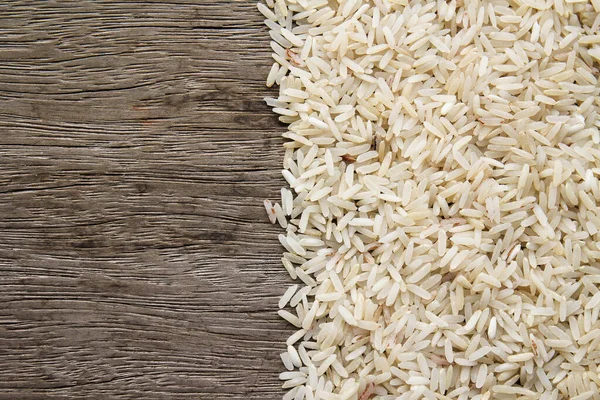 raw rice in wooden bowl on white background