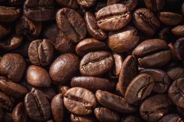 Ahşap arka planda kavrulmuş kahve çekirdekleri.