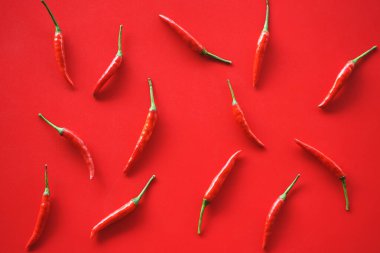 Kırmızı arkaplanda kırmızı biber, üst görünümde.
