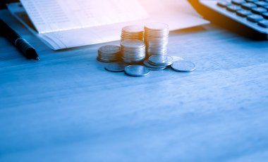 finansal konsept, madeni paralar ve hesap makinesi ahşap masa üzerinde