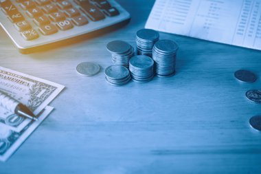 finansal konsept, madeni paralar ve hesap makinesi ahşap masa üzerinde