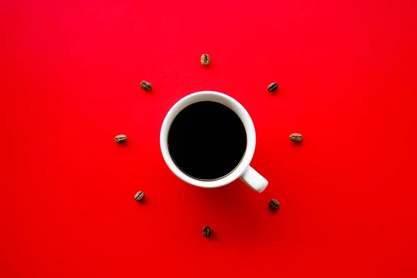 Черная Чашка Кофейными Зёрнами Красном Фоне — стоковое фото