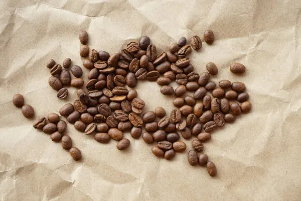 コーヒー豆とコーヒー豆を茶色の紙の背景に — ストック写真