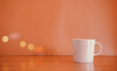 Masanın üzerinde bokeh lambasıyla bir fincan kahve..