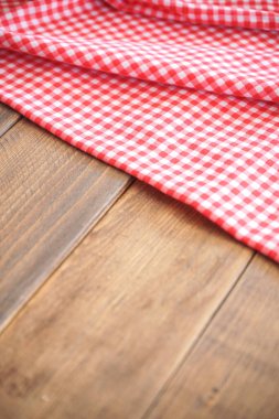 Ahşap arka planda boş kırmızı kareli peçete. Üst Manzara. Mesajın için yer aç. düz yat