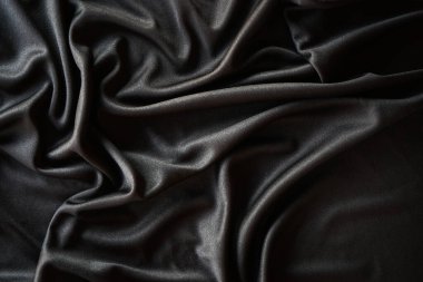 Koyu ipek kumaş. Siyah kumaş arka plan. Dalgalı tekstil, kumaş dokusu