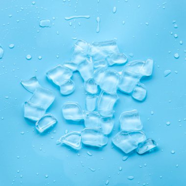 Mavi zemin üzerinde su sıçraması olan buz küpü