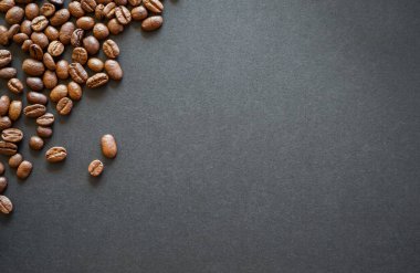 Kahverengi kağıt üzerinde kavrulmuş kahve çekirdekleri.