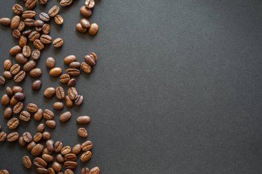 Kahverengi ve beyaz kahve çekirdekleri koyu arkaplanda, üst görünümde, kopyalama alanı