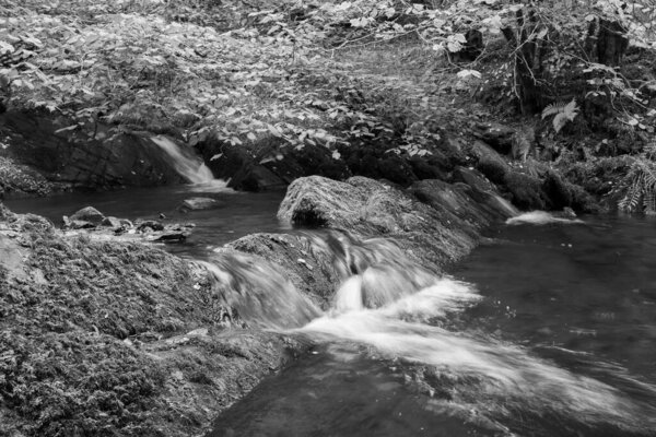 Long exposure of a waterfall on the Horner Water river flowing through Horner woods in Somerset