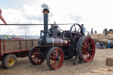 Tarrant Hinton. Dorset. Birleşik Krallık. 25 Ağustos 2022. 1910 Allchin çekici motoru Evedon Lad, Büyük Dorset Buhar Fuarı 'nda eski bir harman makinesine güç veriyor.