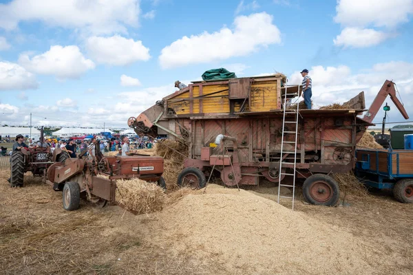 stock image Tarrant Hinton.Dorset.United Kingdom.August 25th 2022.Enthusiasts are operating an old fashioned threshing machine at the Great Dorset Steam Fair