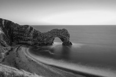 Durdle Kapısı 'nda alacakaranlıkta uzun süre durgun deniz manzarası