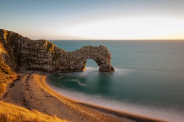 Durdle Kapısı 'nda alacakaranlıkta uzun süre durgun deniz manzarası