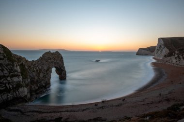 Durdle Kapısı 'nda alacakaranlıkta uzun süre durgun deniz manzarası