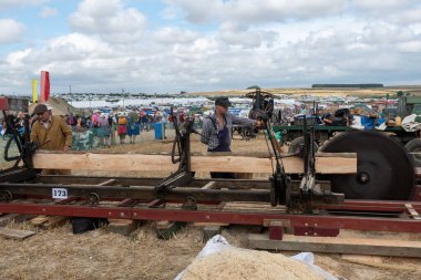 Tarrant Hinton. Dorset. Birleşik Krallık. 25 Ağustos 2022. Coşkulu insanlar Büyük Dorset Buhar Fuarı 'nda eski moda bir testere ile tahta kesiyorlar.