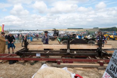 Tarrant Hinton. Dorset. Birleşik Krallık. 25 Ağustos 2022. Coşkulu insanlar Büyük Dorset Buhar Fuarı 'nda eski moda bir testere ile tahta kesiyorlar.