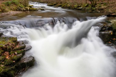 Long exposure of the Watersmeet Bridge waterfall on the East Lyn river at Watersmeet In Exmoor National Park in autumn