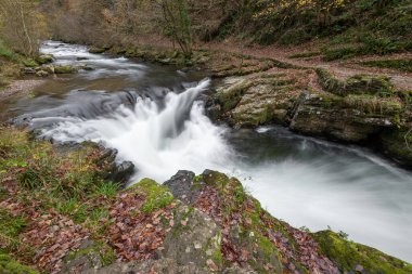 Long exposure of the Watersmeet Bridge waterfall on the East Lyn river at Watersmeet In Exmoor National Park in autumn
